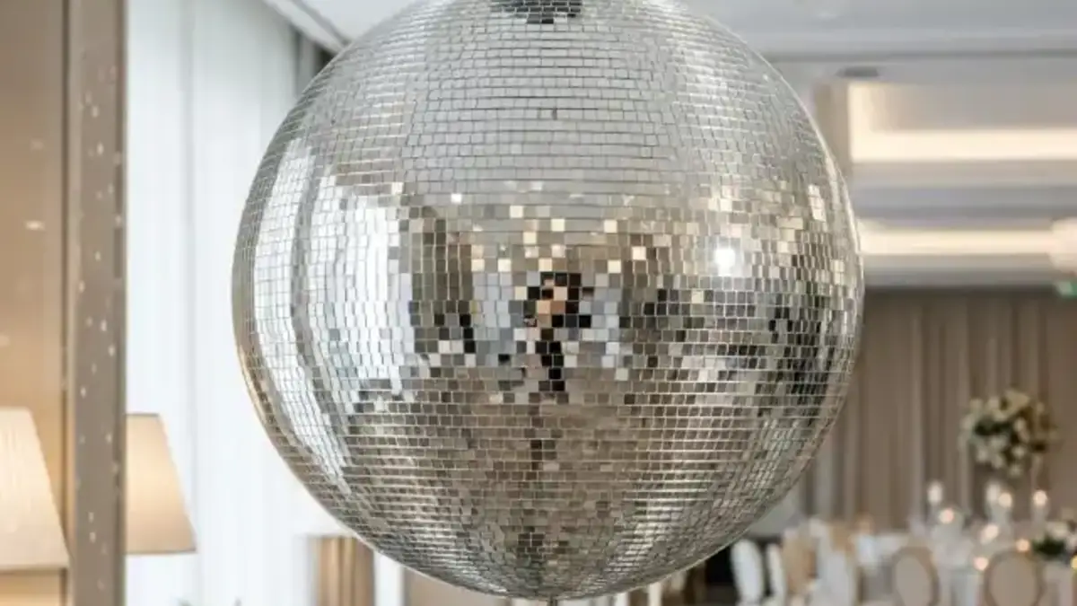 Bola de disco mediana suspendida sobre pista de baile iluminada