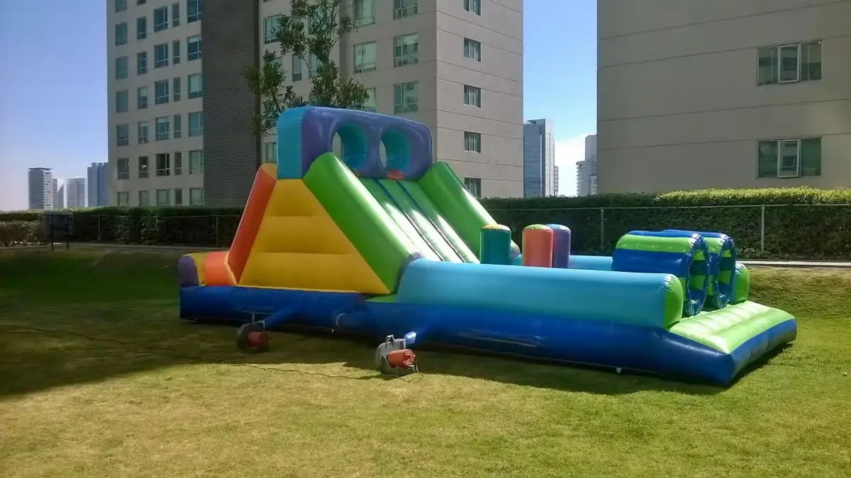 Brincolín grande tipo circuito instalado en jardín amplio