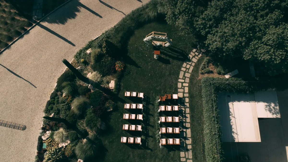 Drones para bodas: vista aérea de una ceremonia al aire libre con sillas en el jardín