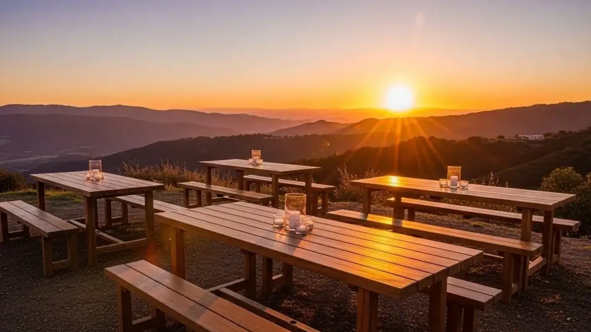 Mesas tipo picnic de madera montadas al atardecer para fiesta
