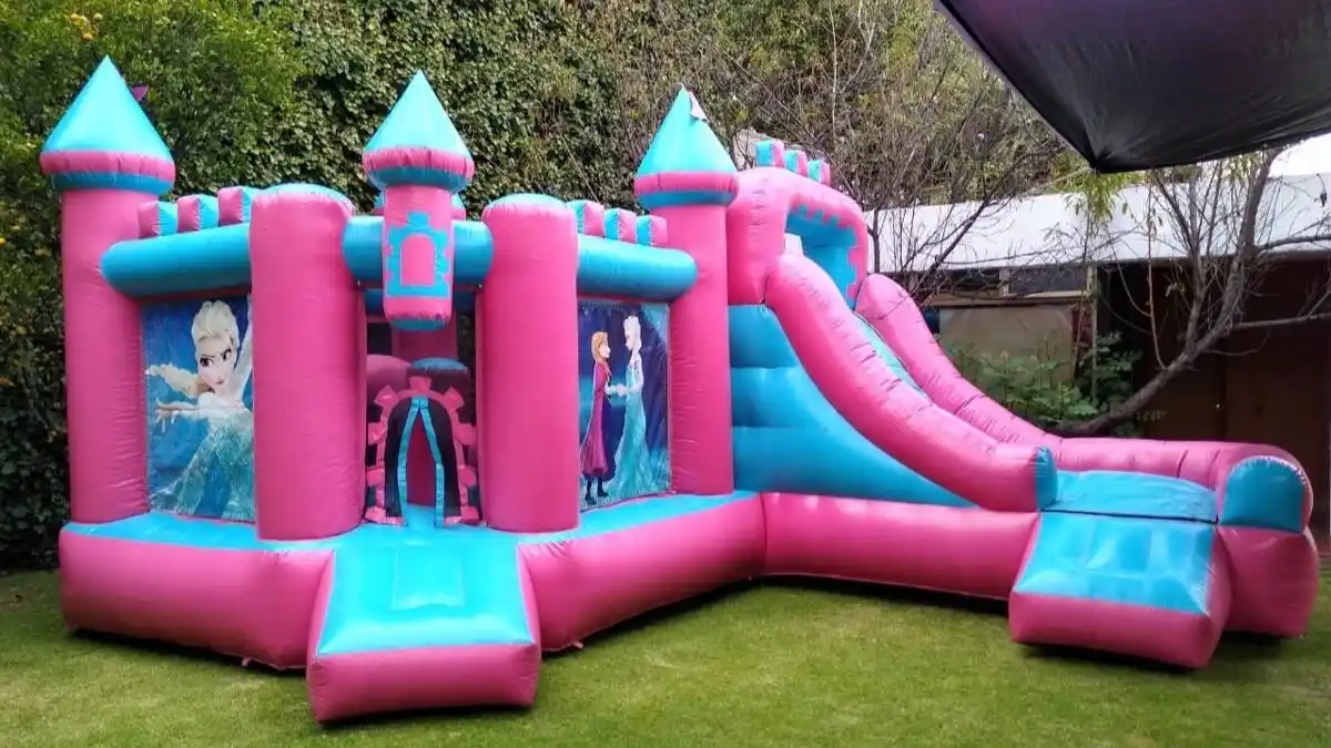 Castillo inflable de princesas con doble resbaladilla en jardín