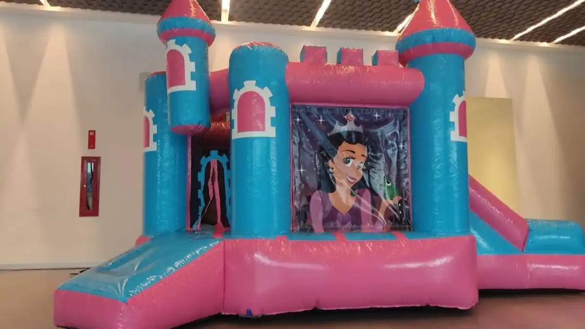 Castillo inflable rosa y azul instalado en jardín para fiesta