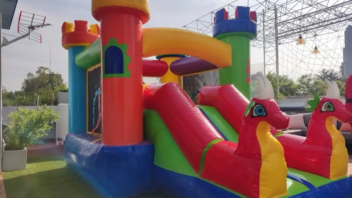 Inflable de castillo multicolor con resbaladilla en terraza exterior