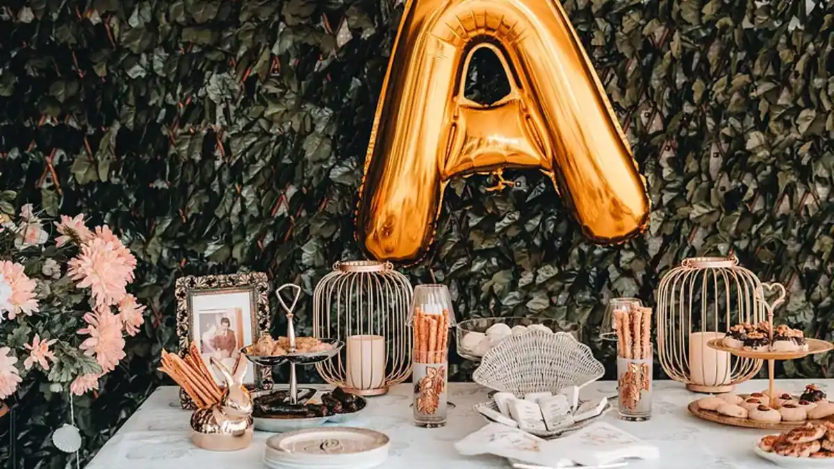 Mesa de dulces para graduación con globo dorado y postres