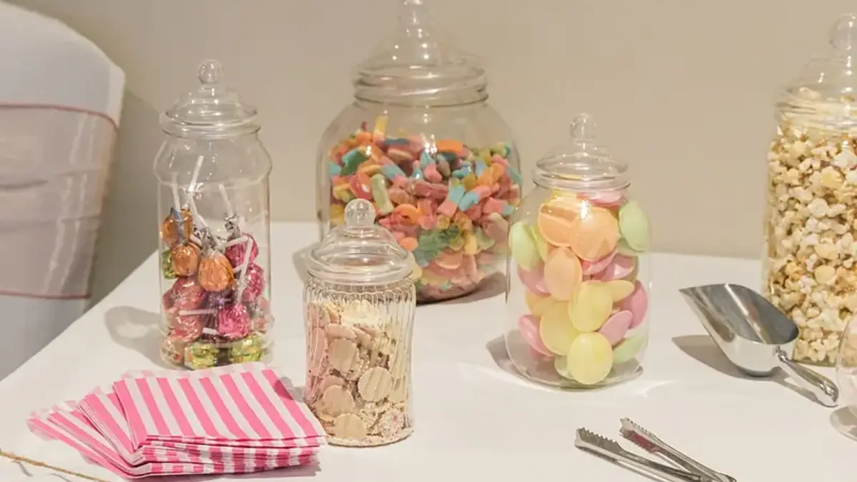 Candy bar con frascos de dulces y utensilios de servicio