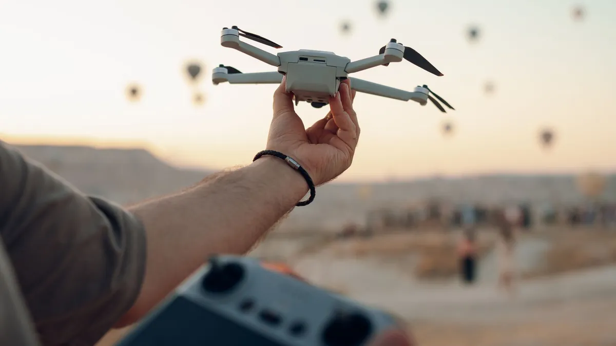 Renta de drones con piloto: operador sostiene el dron y el control remoto antes del despegue