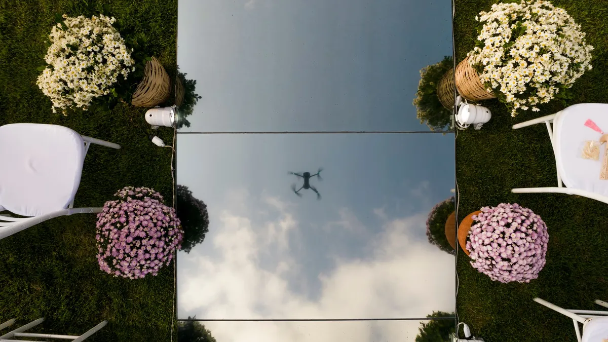 Renta de drones para eventos: dron reflejado en el espejo del pasillo de una boda en jardín
