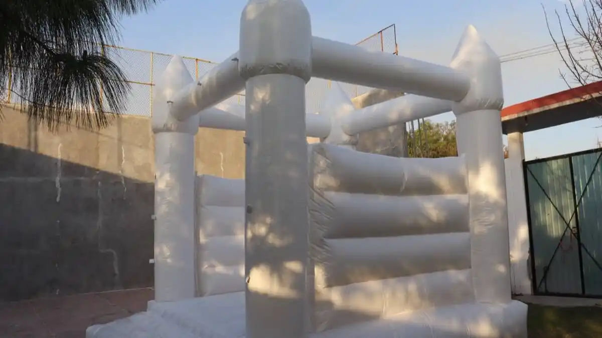 Castillo inflable blanco instalado en jardín durante celebración exterior