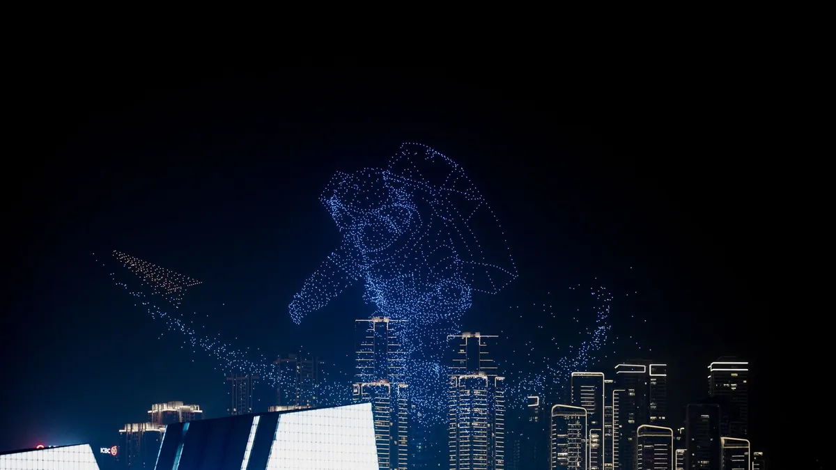 Show de drones: enjambre de drones con luces formando una figura sobre una ciudad de noche