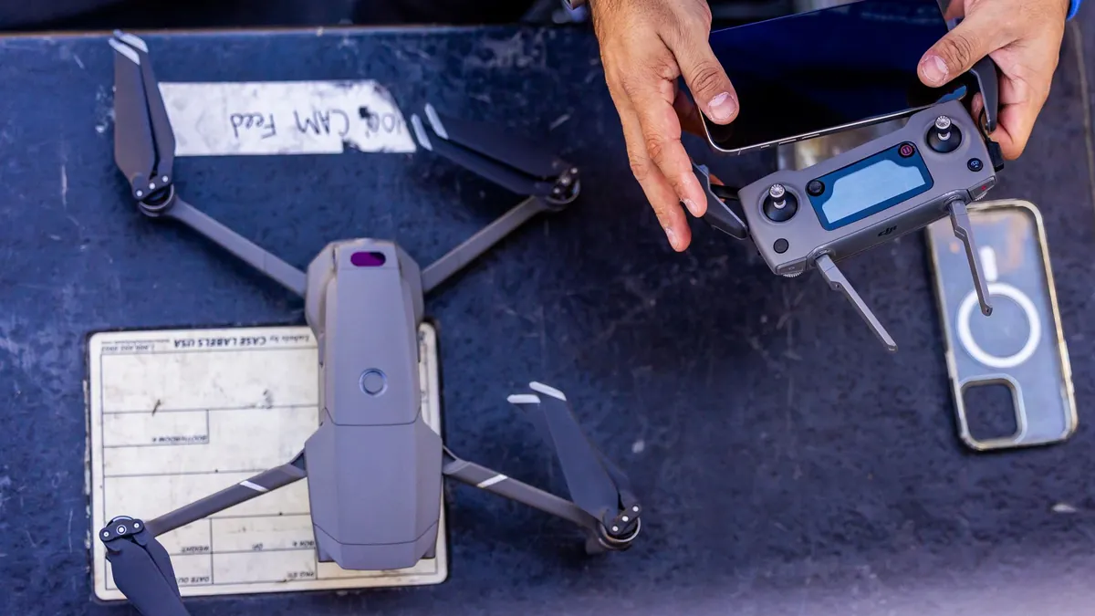Venta de drones: dron plegable y control remoto sobre una mesa durante la revisión del equipo