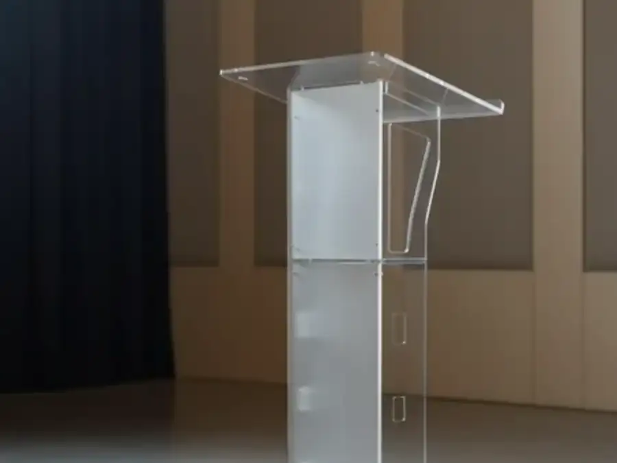 Atril de acrílico transparente colocado en escenario para conferencia
