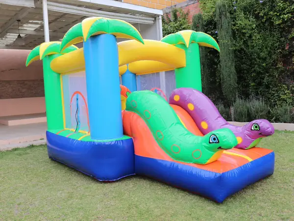 Castillo inflable de jungla con resbaladilla en área exterior