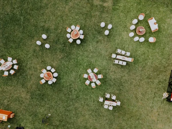 Fotografía aérea con dron de mesas de un evento en jardín