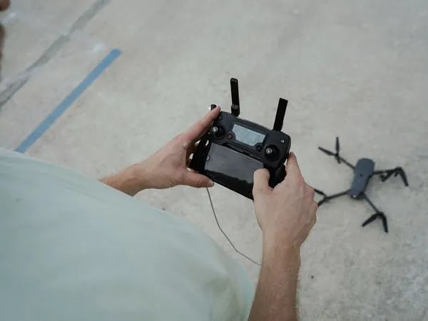 Piloto de drones con control remoto preparando el despegue para un servicio de renta