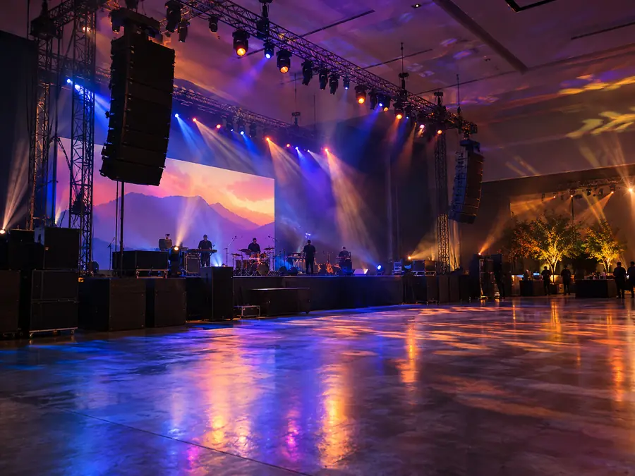 Line array colgado junto al escenario en un salón