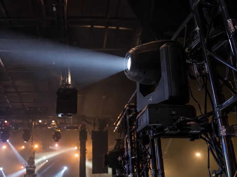 Cabeza móvil profesional sobre truss con haz definido en niebla