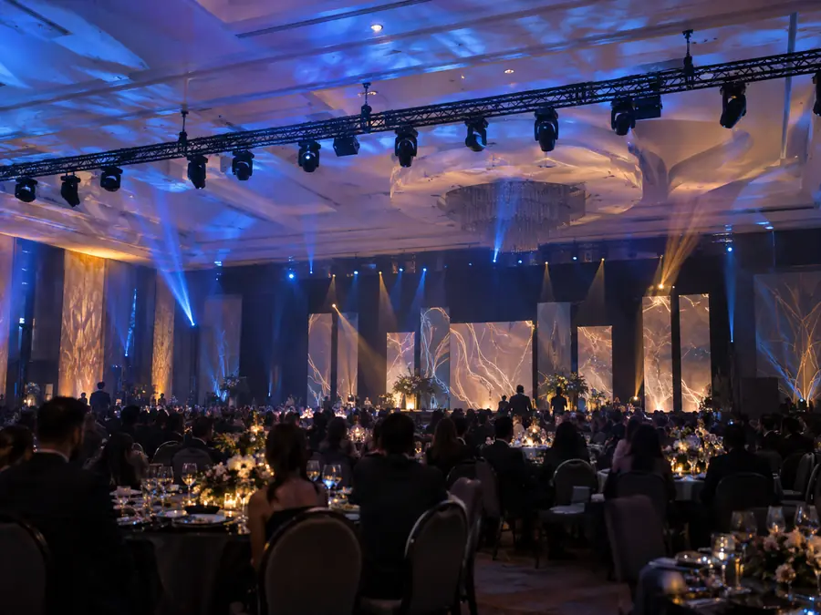 Salón de gala con cabezas móviles iluminando techo y muros