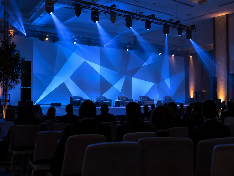 Muro de evento corporativo con patrón geométrico proyectado