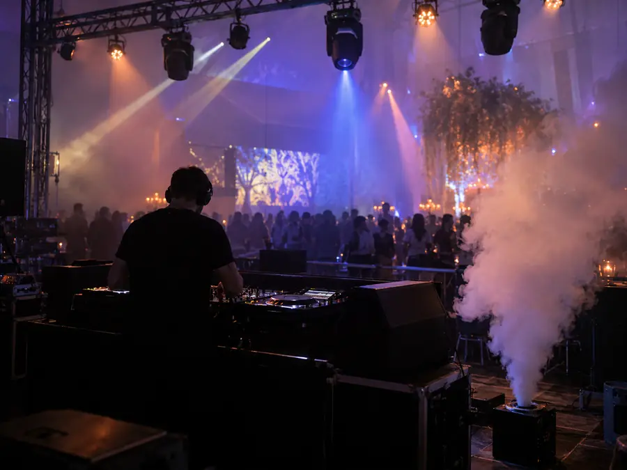 Máquina de humo profesional junto a la cabina del DJ