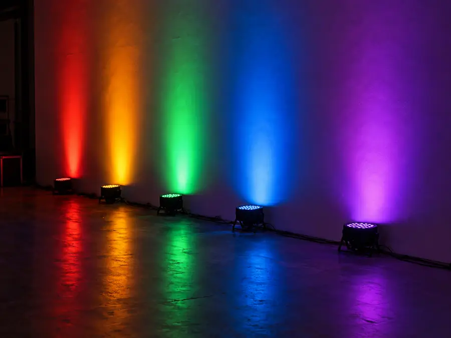 Luces PAR LED de colores alineadas junto a un muro