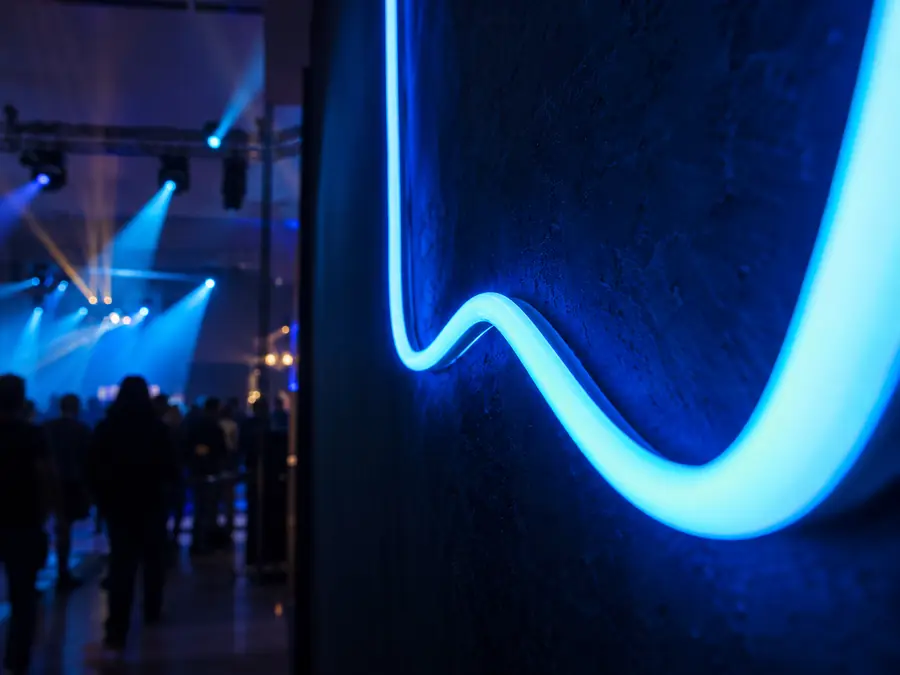 Detalle de tubo de neón LED azul sobre muro oscuro