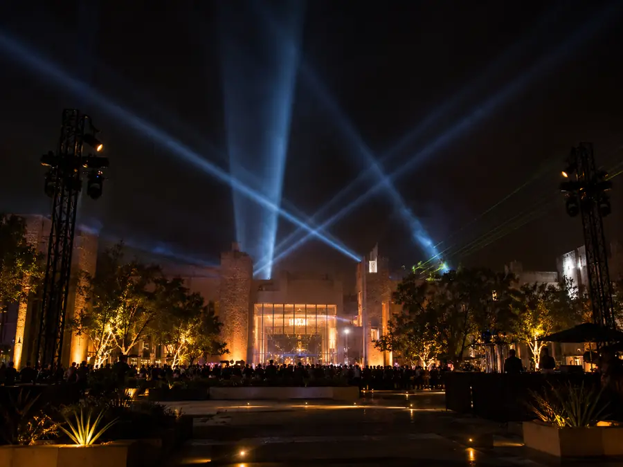 Evento de inauguración con reflectores cruzados sobre el acceso
