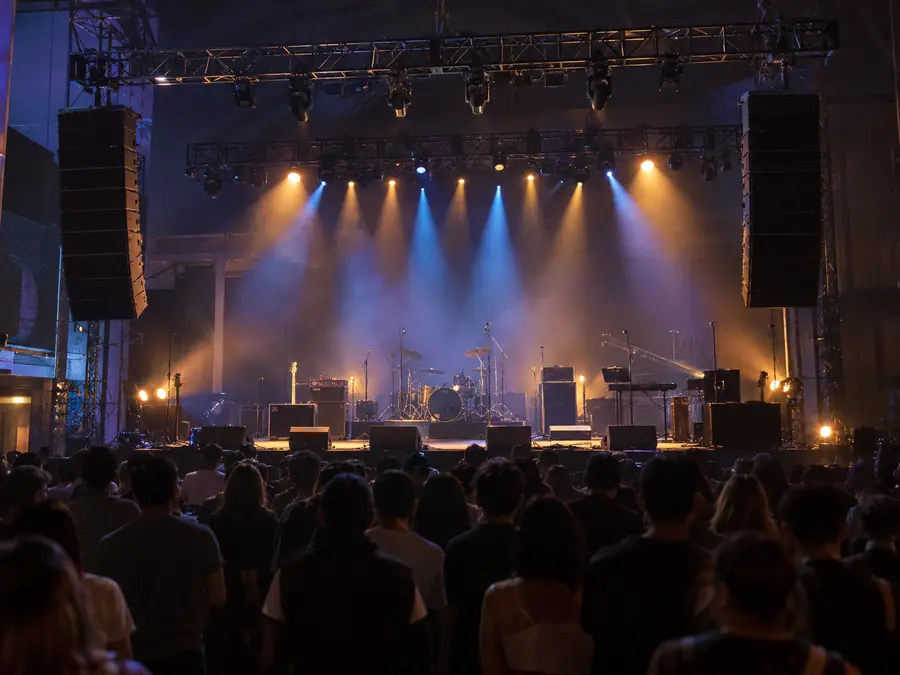 Escenario con line array, monitores y micrófonos